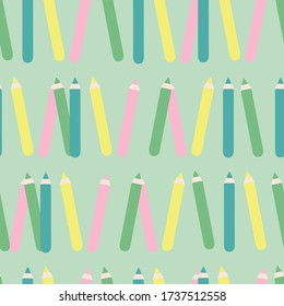 Seamless pattern with pencils in a green background