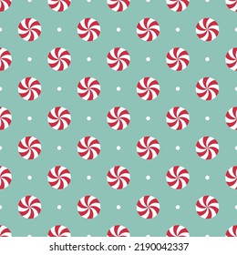 Seamless pattern with peppermint candies. Red and white round mint candies on mint green background.