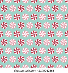 Seamless pattern with peppermint candies. Red and pink round mint candies on light blue background.