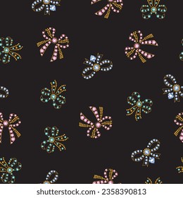 Seamless pattern with pink, green and blue jeweled golden bows on a black background