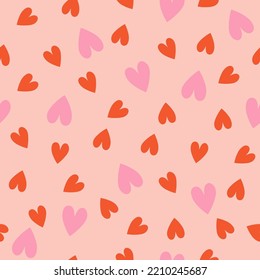 Seamless pattern with pink and red hearts. Vector graphics.