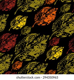 seamless pattern prints birch leaves in autumn colors on a black background