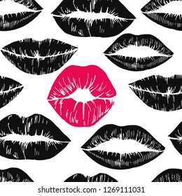 Seamless pattern of the prints of women's lips. On a white background separate prints of black and red lipstick.