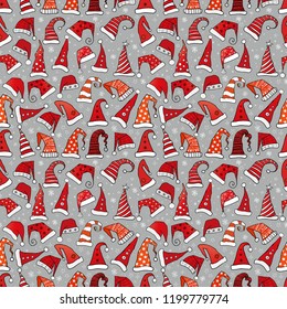 Seamless pattern with red Christmas Santa hats on grey background. Vector illustratio