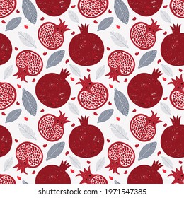Seamless pattern with red pomegranate fruits and seeds on white background. Juicy tropical fruits. Design wallpaper, fabric, wrapping paper or decoration. Hand drawn illustration in vintage style