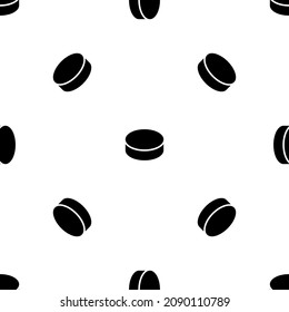 Seamless pattern of repeated black hockey pucks. Elements are evenly spaced and some are rotated. Vector illustration on white background