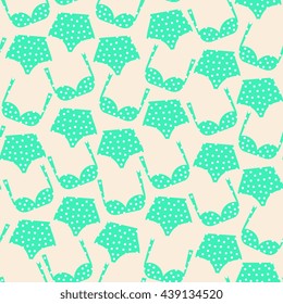 Seamless pattern with retro bikinis in green with polka dots in white.