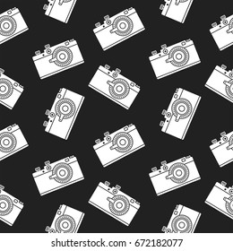 Seamless pattern with a retro film camera on a black background. Decor for textiles, wrapping paper, scrapbooking. Flat vector cartoon illustration. Objects isolated.