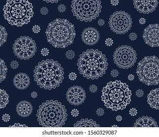Seamless pattern with round white mandalas in snowflakes on a dark background.