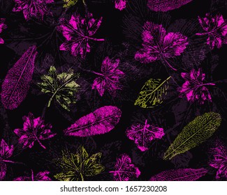 Seamless pattern with scattered leaf prints. Pink and yellow print on a dark background.