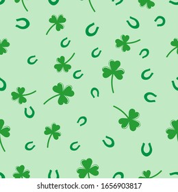 Seamless pattern  with shamrock symbol of Ireland and horseshoe,   Vector  illustration with green clover, hand drawn in doodle  on color background for design, kids decor, wrapping