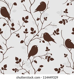 Seamless pattern with silhouette of birds sitting on twigs. Vector background with branches of tree. Decorative vintage wallpaper with birds and leaves