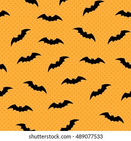 Seamless pattern with silhouettes of bats. Polka dot background for Halloween. Good for design of wrapping paper, invitation and greeting cards.