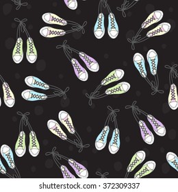 Seamless pattern with sneakers in different colors on a black background.Background for your design. Vector illustration.