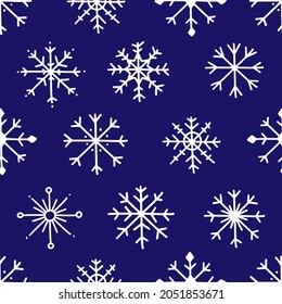 Seamless pattern with snowflakes on a blue background. Vector winter illustration background.