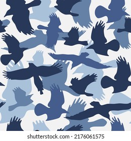 Seamless pattern with soaring birds silhouettes. Blue color camouflage print for textile design