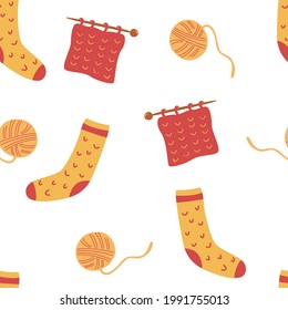 Seamless pattern with socks and knitting. Ball of thread, knitting needles and socks. Cute winter or autumn cozy background for seasonal textile, wrapping paper. Ready production, manufacture. Vector