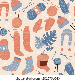 Seamless pattern with socks and knitting elements. Ball of thread, knitting needles and mittens. Cute winter or autumn cozy background for seasonal textile, wrapping paper. Vector flat illustration.