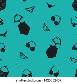 Seamless pattern of swimsuits and bikini on a green background