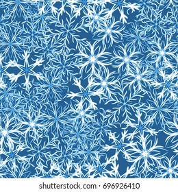 Seamless pattern. Symbolical snowfall. Snowflakes in white and blue tones.