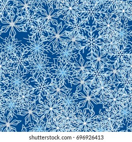 Seamless pattern. Symbolical snowfall. Snowflakes in white and blue tones.