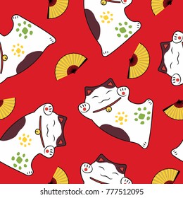 seamless pattern of a traditional luck symbol cat paws up maneki neko and an open fan on a red background