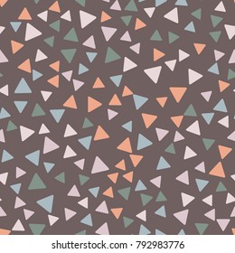 Seamless pattern. Triangles with rounded corners randomly scattered. Autumn colors.