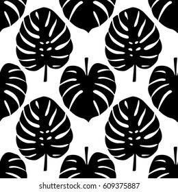 Seamless pattern of tropical black monstera leaves isolated on white. Tropical wallpaper, textile print, exotic background.