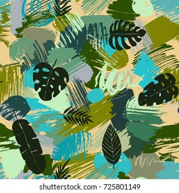 Seamless pattern with tropical leaves on abstract watercolor stains