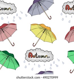 A seamless pattern with umbrellas, clouds and raindrops. Inscription autumn. On a white background.