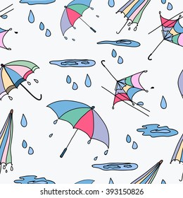 Seamless pattern from umbrellas, puddles, rain in a color 
