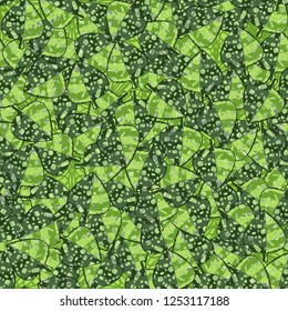 Seamless pattern of variegated green maple leaves lying on a background of square weaving. Camouflage.