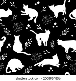 Seamless pattern with white cats silhouettes on black background. Cute kittens.Feline in different poses.Animals sit,lay,relax.Childish monochrome print,wrapping paper.Modern drawing with domestic pet