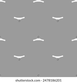 Seamless pattern of white hangers on a gray background