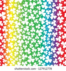 A seamless pattern of white shamrocks on top of a rainbow prism background.