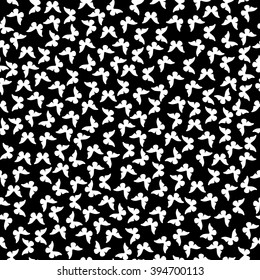 Seamless pattern with white small butterflies on a black background.
