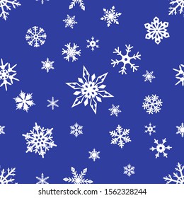 Seamless pattern of white snowflakes of various shapes on a blue background