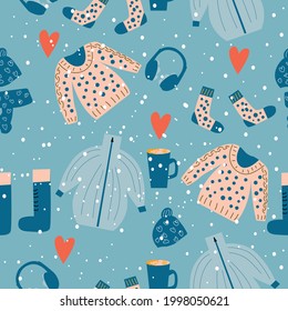 Seamless pattern of winter clothes such as a twist, sweater, hat, scarf, socks, boots, earmuffs and a mug of hot drink, as well as falling snow. Vector illustration 