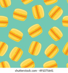 Seamless pattern with yellow macaroon cookies on green. Vector illustration. Eps10