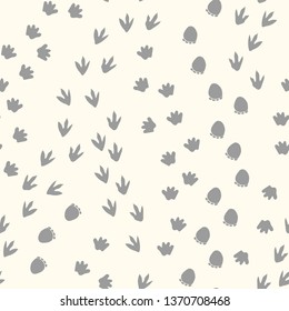 Seamless repeat pattern with different shape gray dinosaur tracks on an ivory background