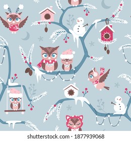 Seamless repeated surface vector pattern design with little brown owls in red and pink winter clothes on blue branches covered with snow on a blue background