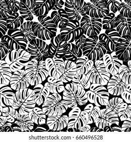 Seamless repeating pattern with silhouettes of palm tree leaves on black and white background.
