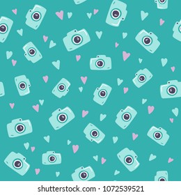 Seamless summer green pattern with cute camera icons and tiny colorful hearts. Flat vector ornament for print on textile, wrapping paper, wallpapers. Repetable tile for background. Travel concept.