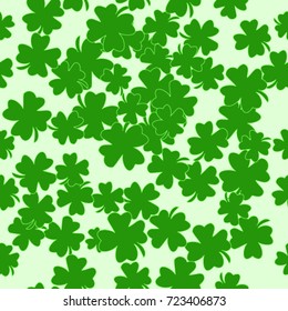 Seamless texture. Clover leaves on a green background