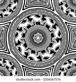 seamless texture with mandalas in primitive, ethnic style rock art cave paintings with animal ornament of the wolves and a solar sign in the center (black and white colors)