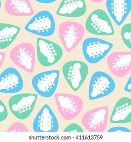 Seamless texture pattern with colorful guitar picks mediators on sandy background