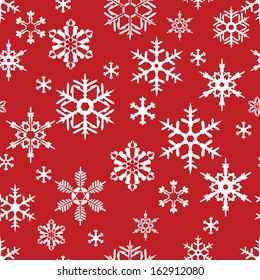 Seamless texture with snowflakes on red background.