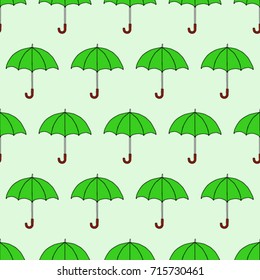 Seamless texture. Umbrellas on a green background