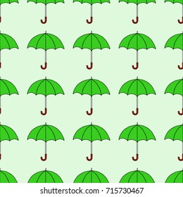Seamless texture. Umbrellas on a green background