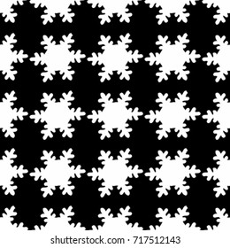 Seamless texture. White snowflakes on a black background
